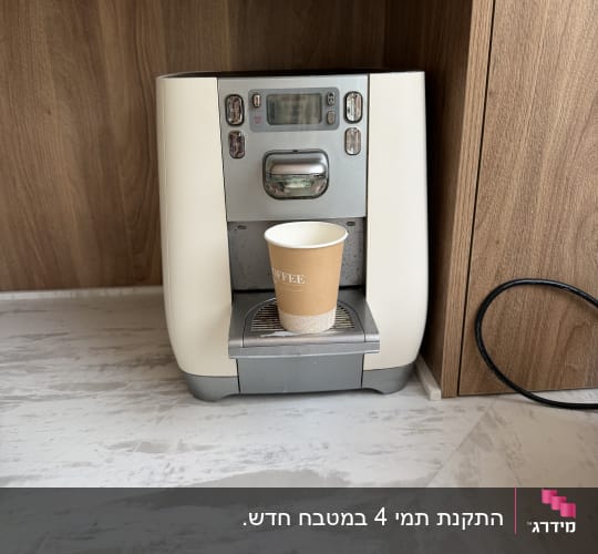 בר מים עם כוס חד פעמית על משטח שיש